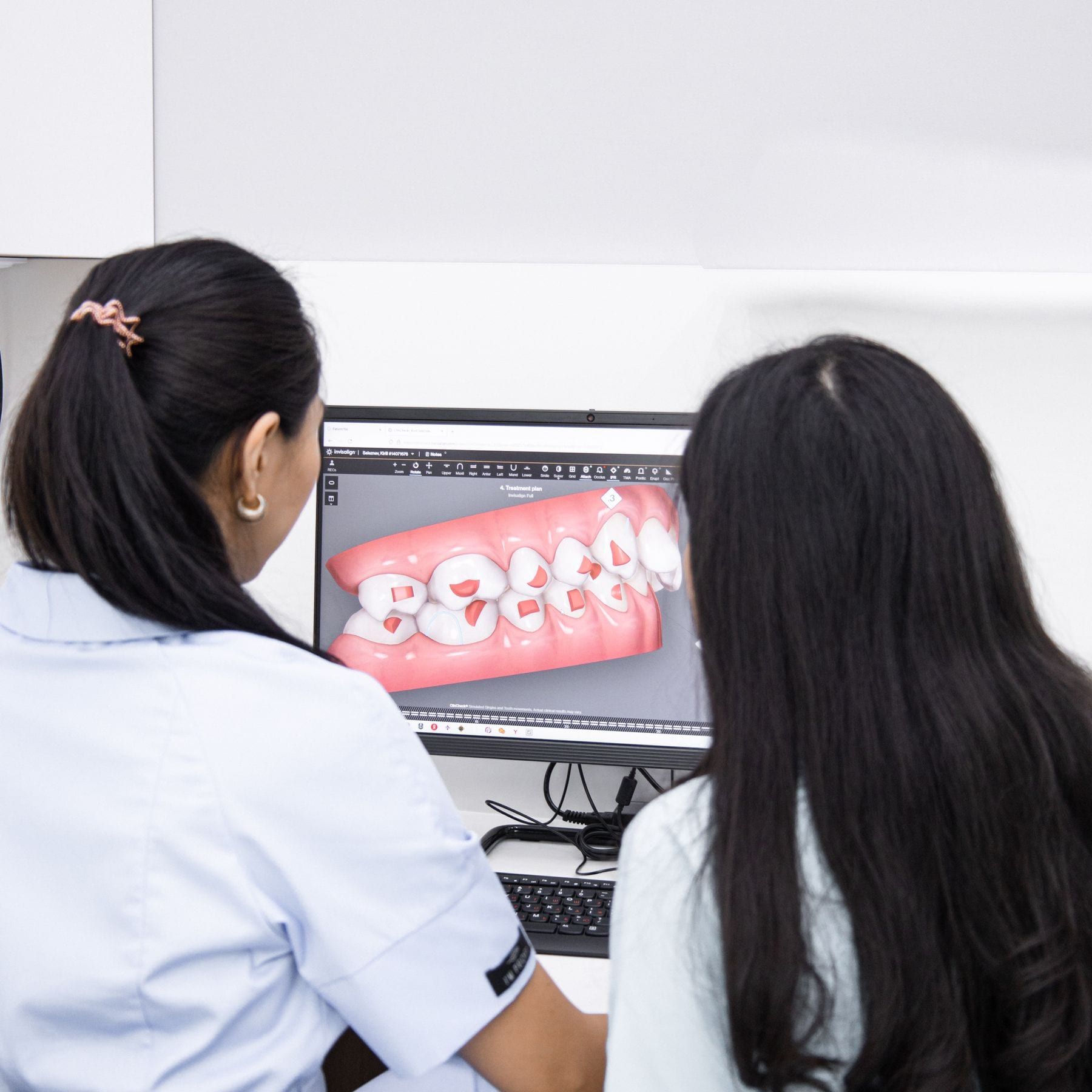 Dentist showing a patient a 3D scan of her teeth on screen