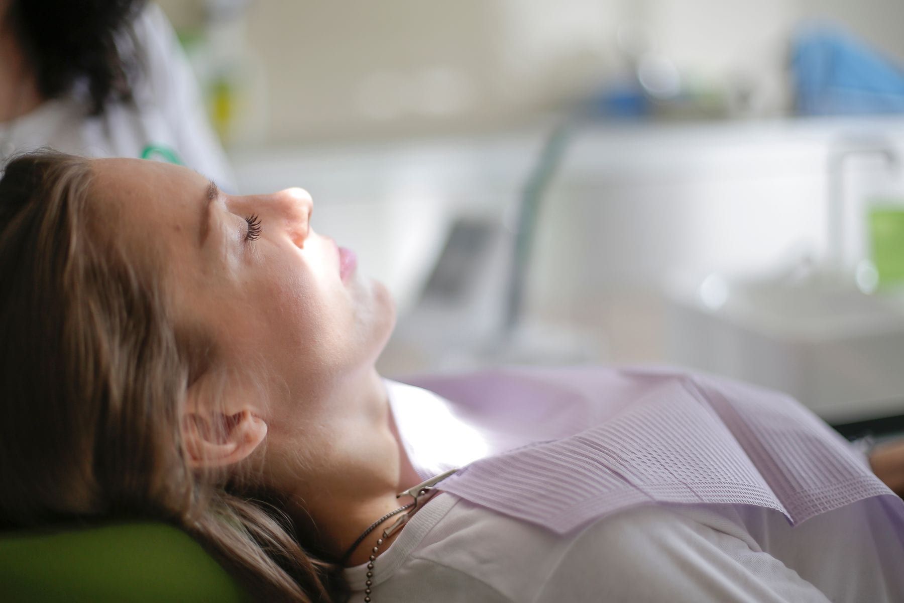 Relaxed patient resting with eyes closed in the dental chair