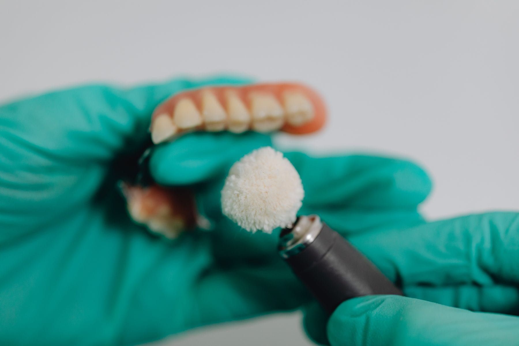 Dental technician polishing a denture