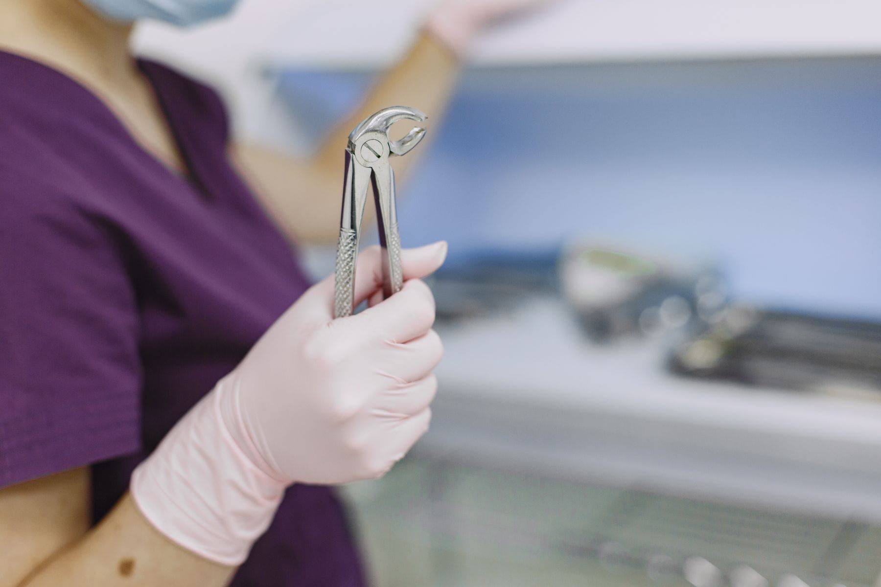 Dentist holding tooth extraction forceps